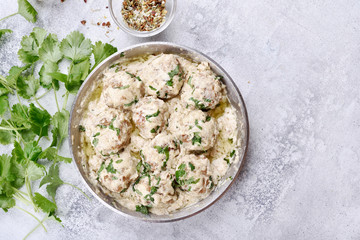 Meatballs with white sauce and green herbs