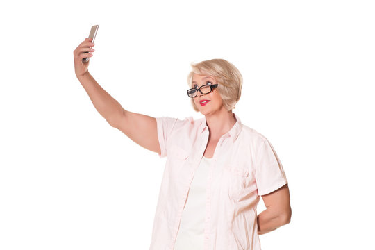 elderly woman with glasses makes selfie over a white background, space for text