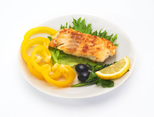 Fried cod fillet with fresh vegetables and slice of lemon