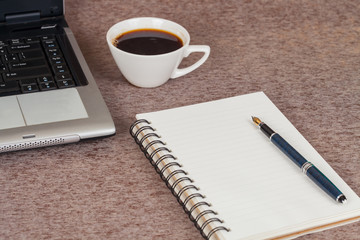 Selective focus office table : laptop, note book and cup on the wooden