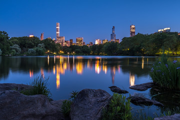 Fototapeta premium Central Park Lake with view of Manhattan skyline at night