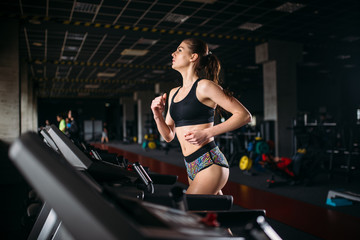 Fototapeta na wymiar Female athlete on a treadmill in sport gym