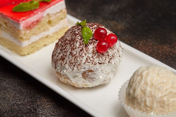 Arrangement of cake and candies on long white plate
