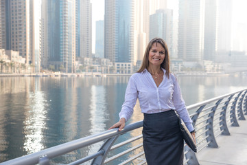 Business woman with a portfolio on a boardwalk.