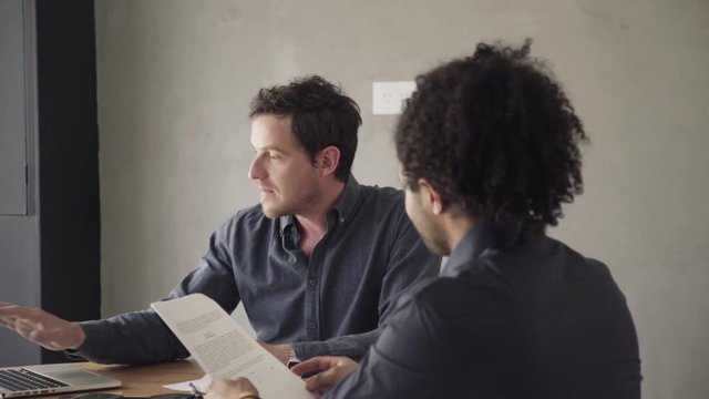 Man reviewing document and listening to explanation