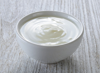 Obraz na płótnie Canvas yogurt in white bowl on wood
