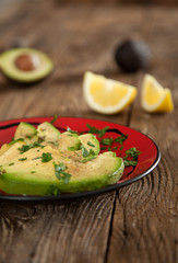 Amusegueule mit Avocadoscheiben auf roten Teller 