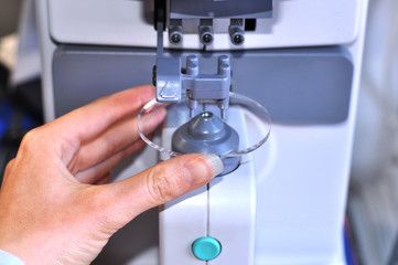 Female optician measuring and preparing glasses,raw material on the digital device in optical store 