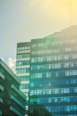 The building is a business center glass with green and blue windows, sunlight and glare