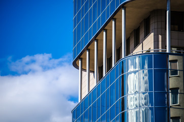 The building is a business center glass with green and blue windows, sunlight and glare