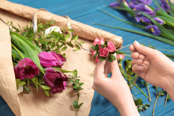 Fototapeta na wymiar Female florist making floral composition on wooden table