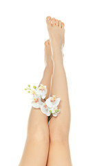 Fototapeta na wymiar Epilation concept. Legs of beautiful young woman and orchid flowers on white background