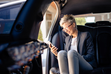 Businesswoman making phone call in limousine