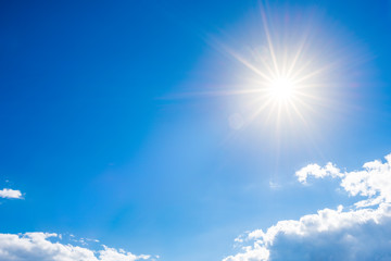 Sunny background, blue sky with clouds and bright sun