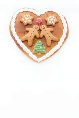 Gingerbread heart decorated with Gingerbread Men, Gingerbread Stars and a Christmas Tree Cookie on white background with lots of copy space. 