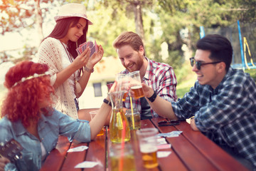 Guys and lassies enjoy and amuse themselves with playing cards and drinking beer