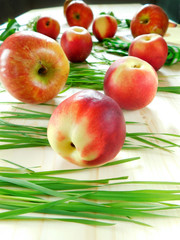 Nectarines and apples on a wooden table illuminated by the sun rays