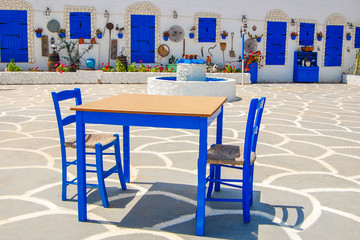 Table with chairs on square in Protaras village with traditional Greek style architecture, Cyprus island