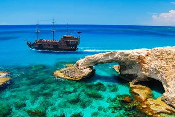 Fotobehang Cyprus Piratenschip dat in de buurt van de beroemde rotsboog op het schiereiland Cavo Greko, het eiland Cyprus vaart