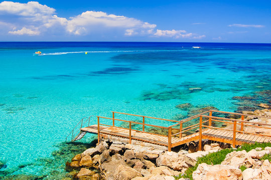 Wooden platform with steps to azure sea water near Protaras, Cyprus island