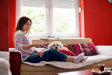 Young woman and her pet on sofa