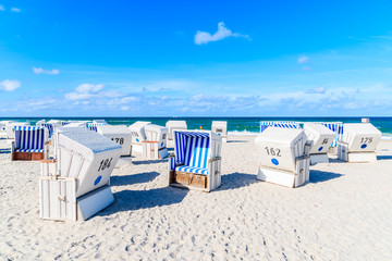 Wicker chairs on sandy beach in Kampen village on Sylt island, North Sea, Germany