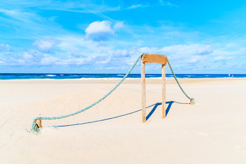 Fototapeta premium Wooden sign with ropes on sandy beach in Kampen village, Sylt island, North Sea, Germany