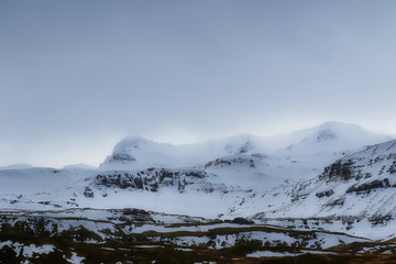 Icelandic landscape with mountains and snow in the distance