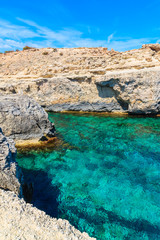 Rocks and sea cove with turquoise sea water in Cala Portinatx bay, Ibiza island, Spain