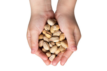 Roasted pistachios in the hands of the child isolated on white background.