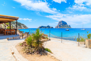 Coastal area and restaurant building at Cala d'Hort beach on sunny summer day, Ibiza island, Spain