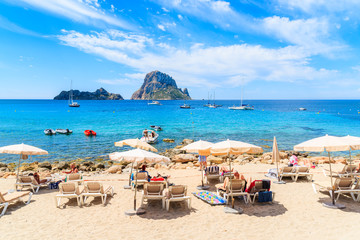 IBIZA ISLAND, SPAIN - MAY 18, 2017: Tourists sunbathing on idyllic beach of Cala d'Hort, Ibiza...