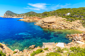 Naklejka na ściany i meble Blue sea water of Punta Galera bay surrounded by amazing stone formations, Ibiza island, Spain