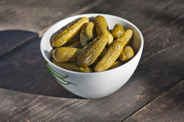 Marinated cucumbers in a bowl. Gherkins in a bowl on the table. Salted cucumbers. Cold starters. Kitchen ingredients
