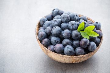 Fresh blueberries natural coconut in a bowl on a gray background.