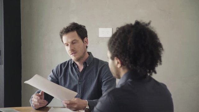 Man reviewing document and listening to explanation