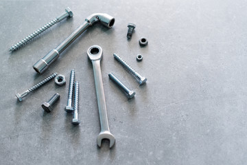 Construction tools. The screws, nuts and bolts on concrete background. Repair, home improvement concept. Space for text, top view, flat lay.