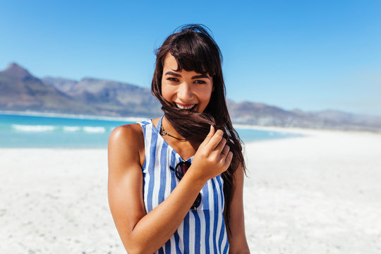 Young woman at the beach and smiling