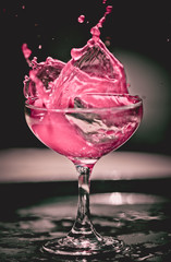 pink drink splashing in glass