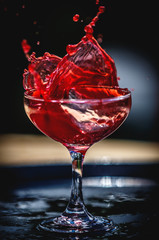 red drink splashing in glass