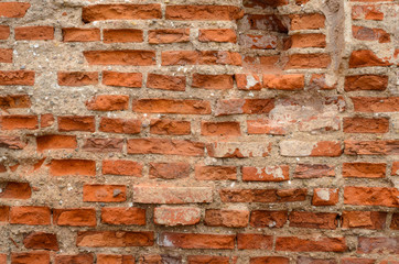 Red brick wall texture shattered by time. Grunge background