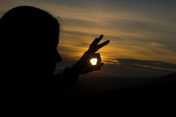 Girl's hand on sunset background