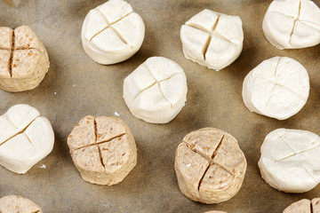 unbaked bread rolls on a wooden background