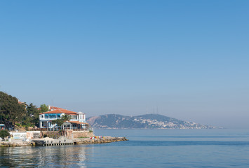 Naklejka na ściany i meble View of Burgazada island from the sea showing a summer house. The island is the third largest one of four islands named Princes' Islands in the Sea of Marmara, near Istanbul, Turkey