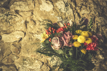 Flower bouquet on stone wall.