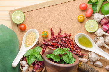 Ingredients for making papaya salad on a wooden table. Set of Thai spices and herbs
