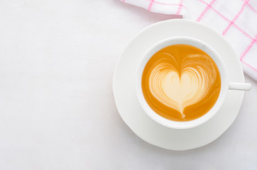 Cup of coffee latte art top view on white wooden background