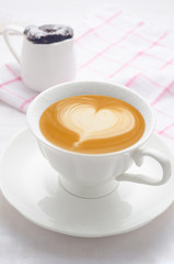 Cup of coffee latte art top view on white wooden background
