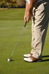 Fototapeta na wymiar Golfer Putting on Autumn Golf Course