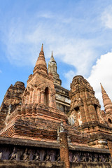 Fototapeta premium Ancient brick chapel under the blue sky at Wat Maha That temple in Sukhothai Historical Park is an old capital and famous landmark of Sukhothai Province, Thailand